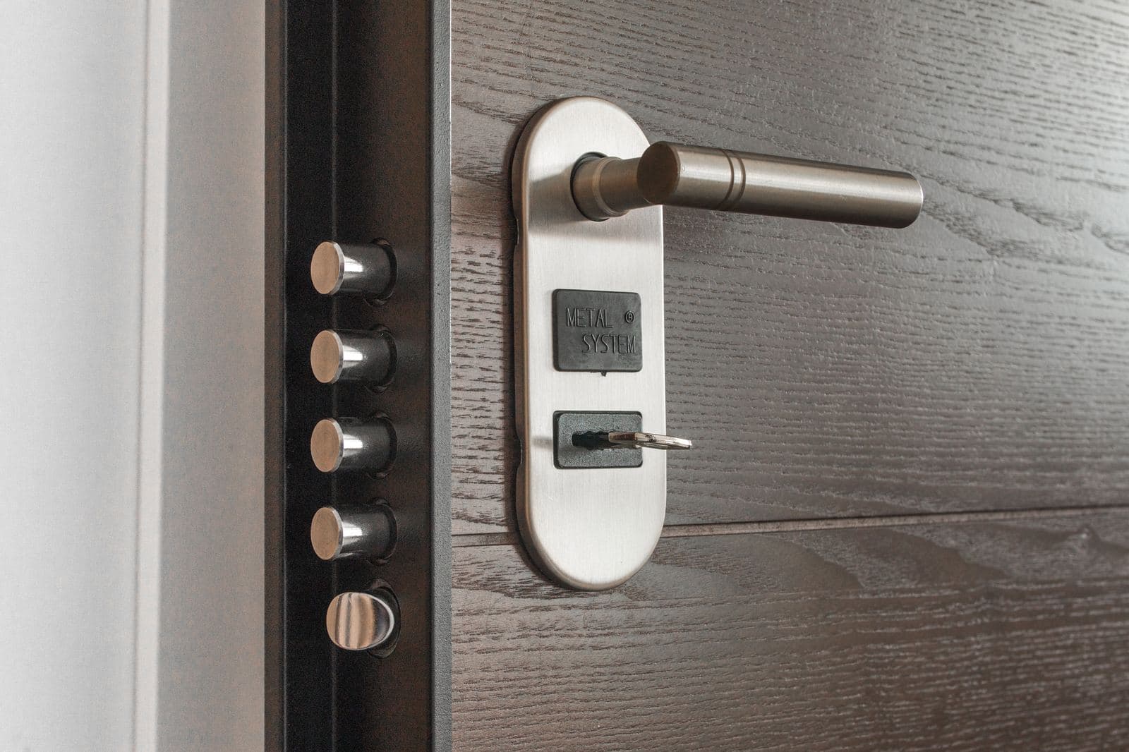 Close-up of a deadbolt lock with key inserted, illustrating a latch alignment issue.