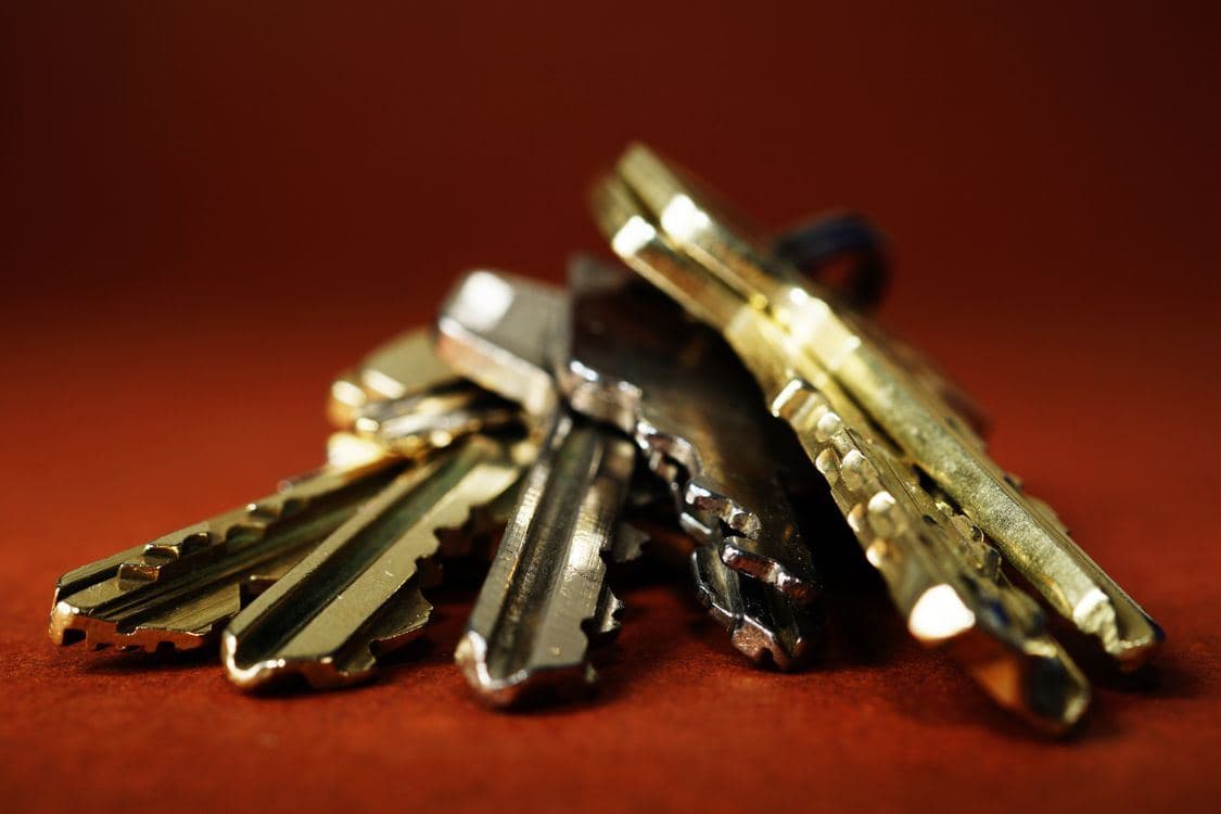 Pile of brass keys representing a landlord's master key system for multiple rental units.